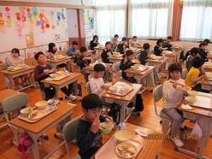 教室で給食を食べる小学生たちの写真